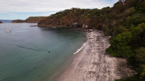 Small-boat-coming-ashore-on-a-tropical-beach-paradise-in-Costa-Rica