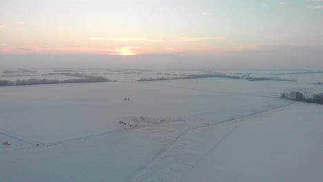 Vista-Aérea-De-Las-Llanuras-Cubiertas-De-Nieve-De-Alberta-Durante-La-Puesta-De-Sol