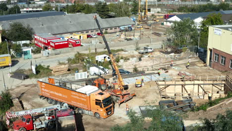 Grúa-Móvil-Moviendo-Vigas-De-Acero-Desde-Un-Camión-En-Un-Sitio-De-Construcción-Urbana