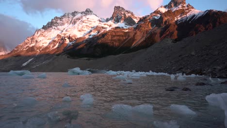 Ice-floating-in-a-lagoon-lake-with-mountain-peak-in-the-background-at-sunset