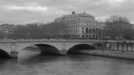 Atemberaubende-Graustufenansicht-Des-Flusses-Seine-Unterhalb-Der-Brücke-In-Paris,-Frankreich