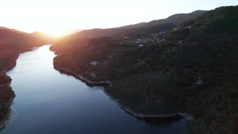 Sonnenuntergang-über-Einem-Wunderschönen-Ruhigen-Fluss,-Umgeben-Von-Hügeln-Und-Bergen-In-Einem-Dorf-In-Portugal