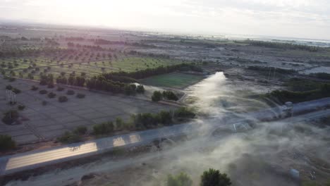 Drone-Aéreo-Disparado-Hacia-Atrás-Sobre-La-Carretera-RCD-En-Baluchistán-Rodeado-De-Tierras-Agrícolas-Durante-La-Mañana
