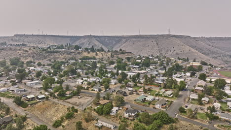 Maupin-Oregon-Aerial-V1-Filmischer-Drohnenüberflug-über-Eine-Stadt-Mit-Gebäuden-Am-Hang,-Die-Eine-Spektakuläre-Naturlandschaft-Mit-Schluchten-Und-Flussbiegungen-An-Einem-Dunstigen-Tag-Einfängt-–-Aufgenommen-Mit-Mavic-3-Cine-–-August-2022