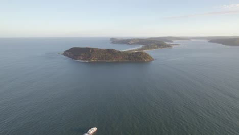 Ferry-Dejando-Estela-En-El-Océano-En-Calma-Rumbo-A-La-Playa-De-Palmeras-Barrenjoey-Promontorio-En-Nsw,-Australia
