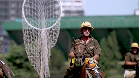 Slow-motion-close-up-shot-of-player-holding-on-to-the-leathered-ball-on-the-horseback,-galloping-and-maneuvering-through-the-crowds-of-opponents-and-teammates-during-Pato-horseball-open-tournament