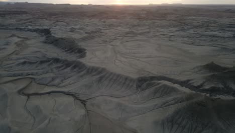 Tilt-pan-reveal-of-geological-landscape-of-badlands-near-Utah-at-sunset