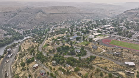 Maupin-Oregon-Aerial-v2-panoramic-panning-view-drone-flyover-remote-small-town-along-the-Deschutes-river-capturing-barren-canyon-landscape-on-a-hazy-day---Shot-with-Mavic-3-Cine---August-2022