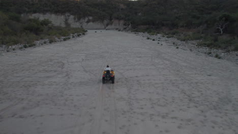 Drone-Siguiendo-A-Un-Hombre-Que-Conducía-Una-Motocicleta-En-Un-Camino-Polvoriento-En-Los-Cabos,-México