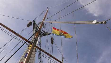 New-Brunswick-provincial-flag-flying-on-a-sailboat-against-a-blue-sky-background
