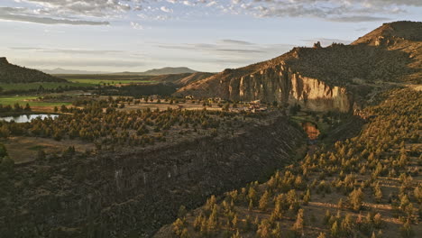 Terrebonne-Oregon-Aerial-v58-flyover-crooked-river-capturing-scenic-landscape-of-Sherwood-canyon,-vastness-of-farmlands-with-ranch-mansions-at-sunset-golden-hour---Shot-with-Mavic-3-Cine---August-2022