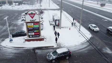 Pedestrians-Walking-Outdoor-On-A-Snowy-Weather-While-Cars-Navigating-Cautiously-On-Slippery-Road-In-Mississauga,-Canada