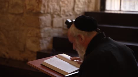 Hombre-Judío-Religioso-Orando-Usando-Tefilín,-Filacterias-Y-Un-Chal-De-Oración-En-Una-Sinagoga