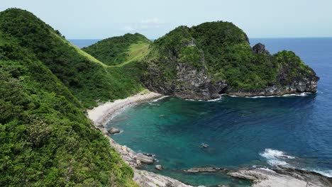 Aerial-orbit-reveal-stunning-idyllic-beach-bay-in-phillipines,-sunny-day