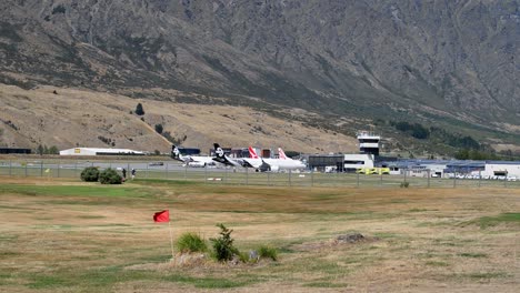 Golf-players-in-front-of-Queenstown-airport-on-sunny-day-in-New-Zealand