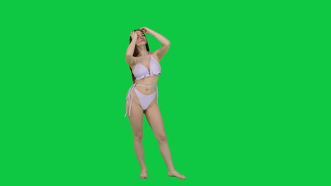 Beautiful-and-thoughtful-female-model-posing-wearing-a-bikini-in-front-of-a-green-screen