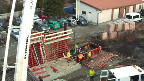 Trabajadores-De-La-Construcción-Bombeando-Hormigón-En-Los-Cimientos-Del-Edificio