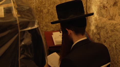 Jewish-worshiper-reading-a-book-near-the-Wailing-Wall-and-praying