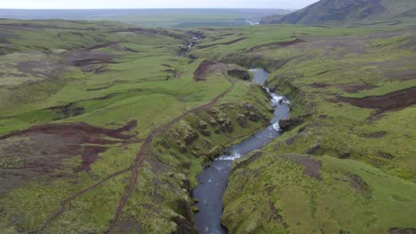 Antena-Alta-Sobre-El-Terreno-Del-Famoso-Monumento-Natural-Y-Atracción-Turística-De-Las-Cataratas-Skogafoss-Y-El-Sendero-Fimmvorduhals-En-Islandia