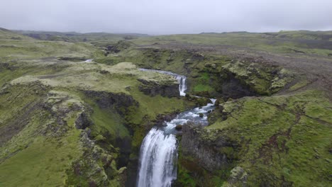 Aerial-high-above-the-famous-natural-landmark-and-tourist-attraction-of-Skogafoss-falls-and-Fimmvorduhals-trail-in-Iceland