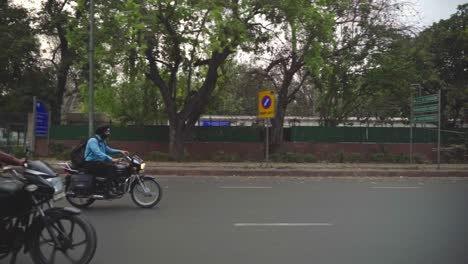 Couple-riding-on-a-motorcycle-in-Rajpath-central-Delhi,-India