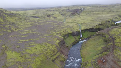 Aerial-high-above-the-terrain-of-the-famous-natural-landmark-and-tourist-attraction-of-Skogafoss-falls-and-Fimmvorduhals-trail-in-Iceland