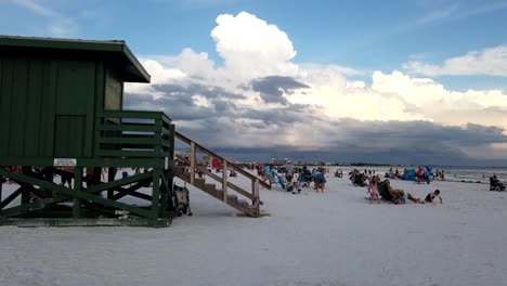Panoramic-timelapse-of-the-beach-in-Florida,-clouds-emerge-and-dissolve-in-a-bright-blue-summer-sky,-cloud-turns-purple-blue-orange-at-the-end-of-the-scenic-shot