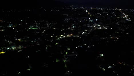 Panoramic-aerial-overview-of-night-lights-of-the-busy-Philippine-island-town-of-Virac,-Catanduanes