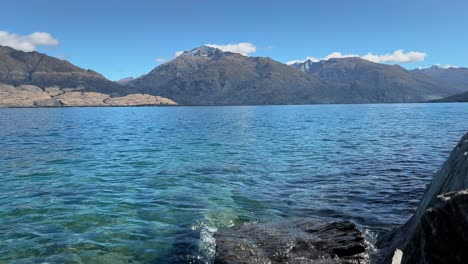 Crystal-clear-water-on-the-shore-of-Lake-Wanaka,-New-Zealand-in-morning-sunlight