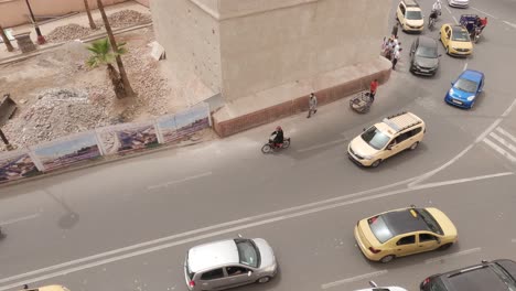 View-of-busy-Marrakesh,-Morocco-traffic-panning-to-a-view-of-Koutoubia-Mosque