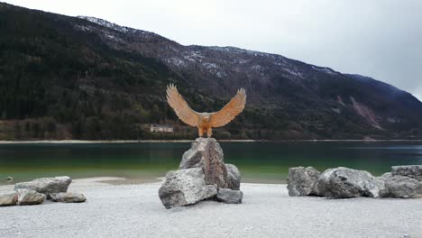 Wooden-Eagle-Sculpture-On-The-Rock-In-Molveno-Lake-In-Trentino,-Italy