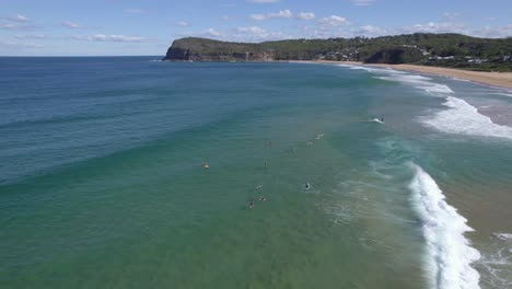 Surfer-Treiben-Auf-Meereswellen-Und-Sonnen-Sich-Am-Copacabana-Strand-In-New-South-Wales,-Australien