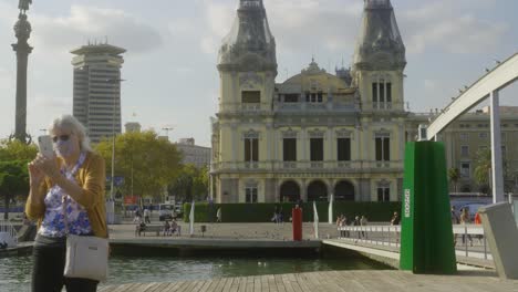 People-walking-over-bridge-Rambla-de-Mar-in-Barcelona,-Spain-on-sunny-day