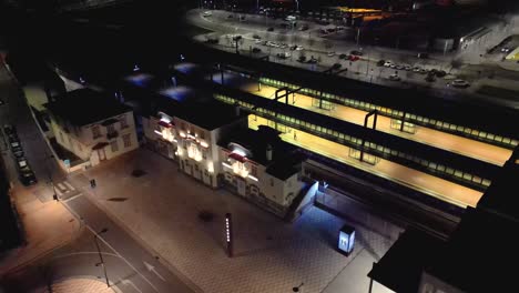 Aerial-drone-rotating-shot-over-an-empty-entrance-of-railway-station-in-Aveiro,-Portugal-at-night-time