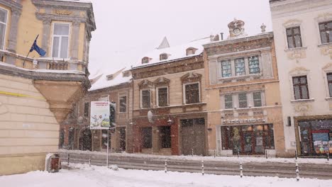 Gebäude-Entlang-Der-Leeren-Straße-Während-Des-Schneesturms-In-Brasov,-Rumänien