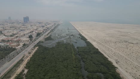 Aerial-flying-over-green-area-in-Dammam,-desert-land-on-right,-Saudi-Arabia