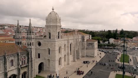 Astounding-Gothic-Style-Of-Jeronimos-Monastery-With-Tourists-Outside-The-Building-On-A-Cloudy-Day-In-Belem,-Lisbon,-Portugal