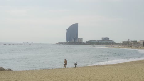 Wide-shot-Barceloneta-Beach-on-cloudy-day-in-Barcelona,-Spain