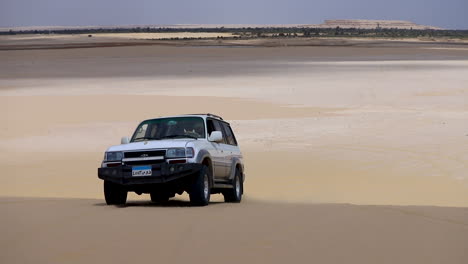 Camp-car-walking-on-the-sand-under-the-hot-sky-in-the-desert