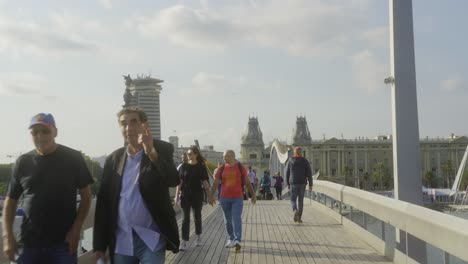 Menschen,-Die-An-Einem-Sonnigen-Tag-über-Die-Brücke-Rambla-De-Mar-In-Barcelona,-Spanien,-Gehen
