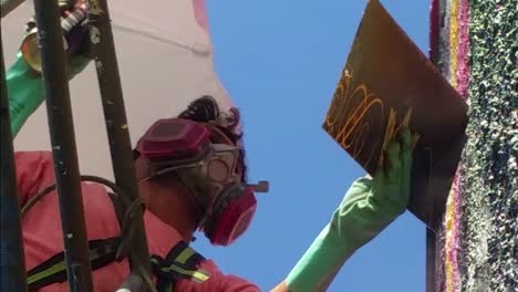 Detail-shot-of-a-man-working-on-a-graffiti-wall