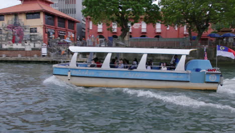 Turistas-Disfrutando-De-Un-Paseo-En-Barco-Por-Las-Tranquilas-Aguas-Del-Río-Malaca,-Toma-Panorámica