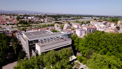 Majestic-Trees-and-Modern-Elegance:-A-Stunning-Aerial-Rotation-of-Perpignan's-Palais-des-Congres-in-a-Green-Oasis
