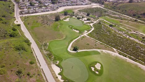 Atemberaubende-Luftaufnahme-Des-Links-Golfplatzes-In-Südkalifornien-Mit-Spielenden-Spielern-Und-Karrenfahren-Mit-üppigen-Fairways-Und-Wunderschönen-Grüns-An-Einem-Warmen,-Sonnigen-Tag