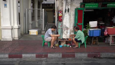 Perlenverkäufer-Wählen-Die-Perlen-Sorgfältig-Aus,-Fädeln-Sie-Auf-Dünne-Schnüre-Und-Erwarten-Kunden-In-Yaowarat-Chinatown,-Bangkok,-Thailand