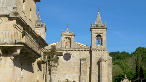 Cross-and-church-of-the-Monastery-of-Santo-Estevo-de-Ribas-de-Sil,-Nogueira-de-Ramuin,-Ourense,-Galicia,-Spain