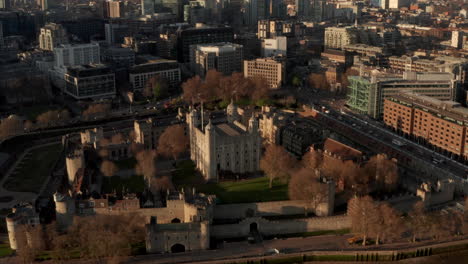 Toma-Aérea-Dando-Vueltas-Alrededor-De-La-Torre-De-Londres,-Panorámica-Hacia-Arriba,-Revelando-Los-Modernos-Rascacielos-De-La-Ciudad-De-Londres.