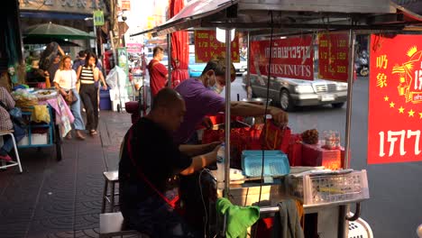 Los-Vendedores-Empaquetan-Y-Exhiben-Castañas,-Se-Preparan-Para-Los-Negocios-Y-Esperan-A-Los-Clientes-En-El-Famoso-Barrio-Chino-De-Yaowarat,-Bangkok,-Tailandia