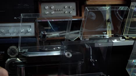 Elektronischer-Vintage-Audioladen-Mit-Vinyl-Musikausrüstung-Und-Einem-Vintage-Mikrofon,-Das-Sich-Auf-Dem-Plattenspieler-Dreht,-Elvis-Presley-Stil,-Handaufnahme