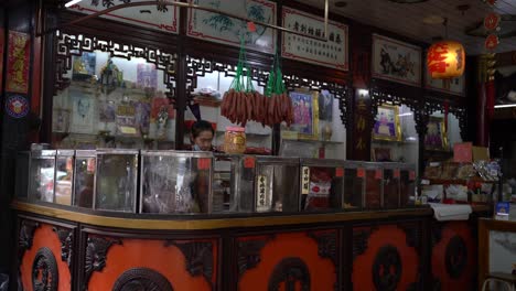 Sicht-Einer-Ladenbesitzerin,-Die-Damit-Beschäftigt-Ist,-Getrocknete-Lebensmittel-In-Yaowarat-Chinatown,-Bangkok,-Thailand-Zu-Verpacken-Und-Zuzubereiten